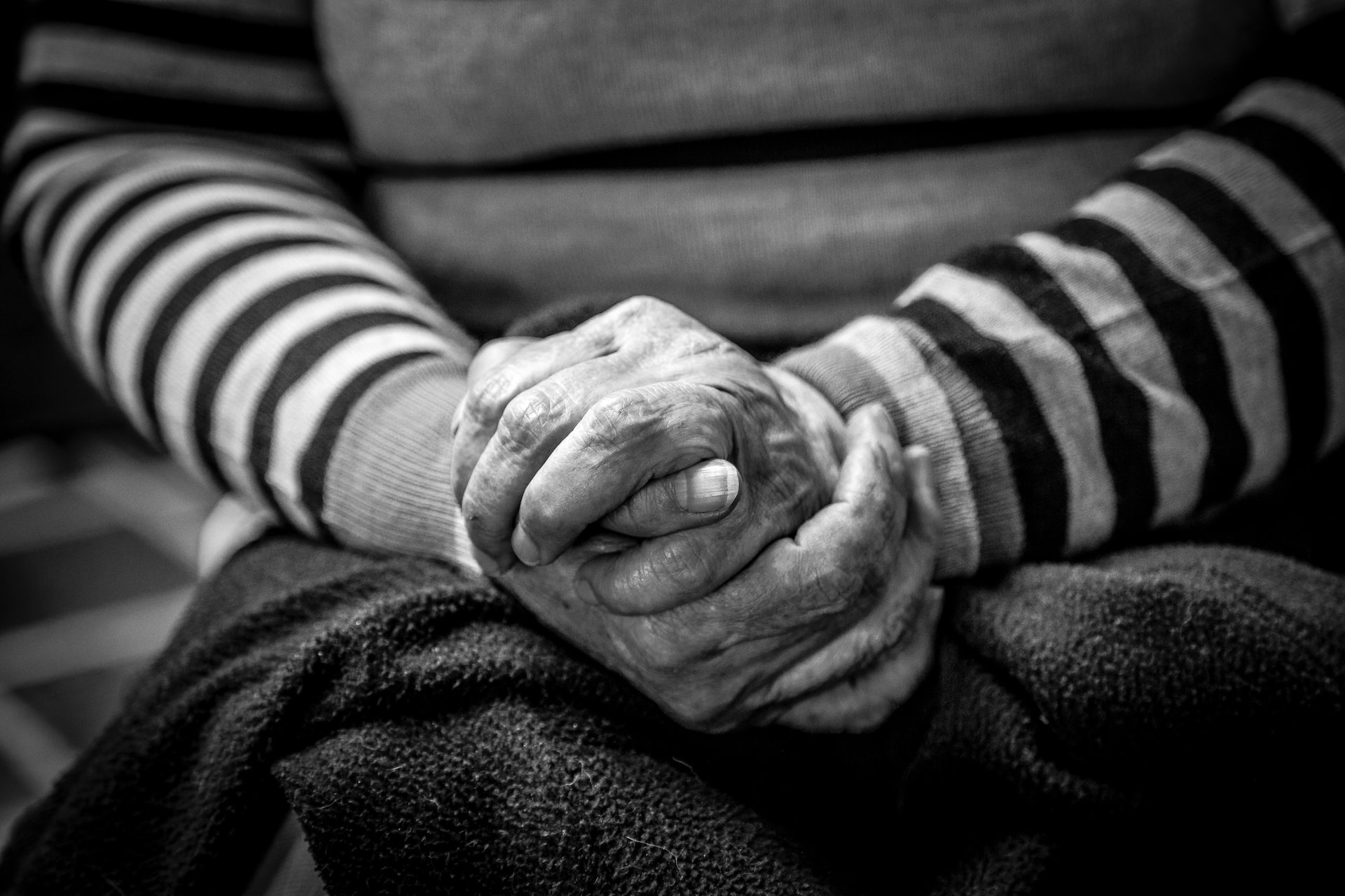black and white image of elderly woman holding her hands