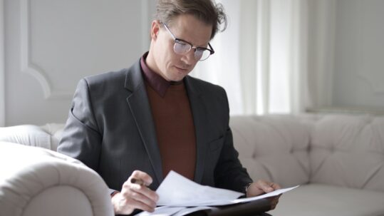 nursing home arbitration agreement -- man sitting on sofa reviewing paperwork