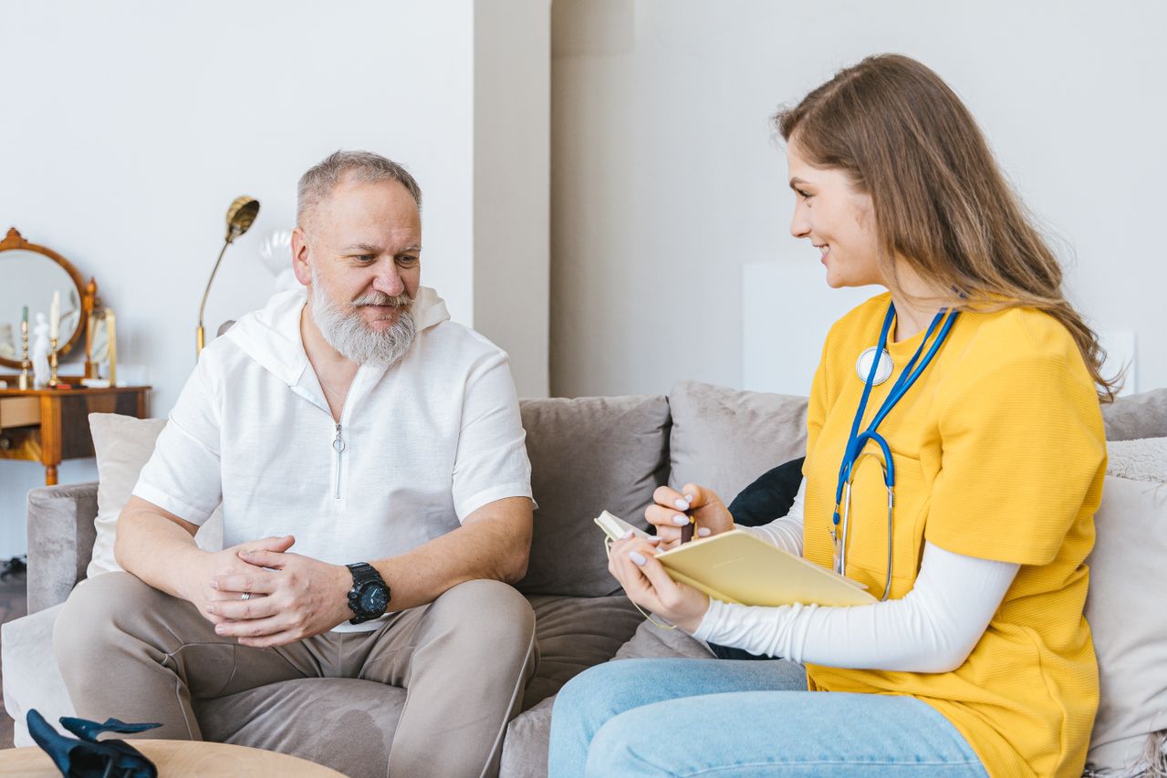 senior man talking to long-term care facility nurse